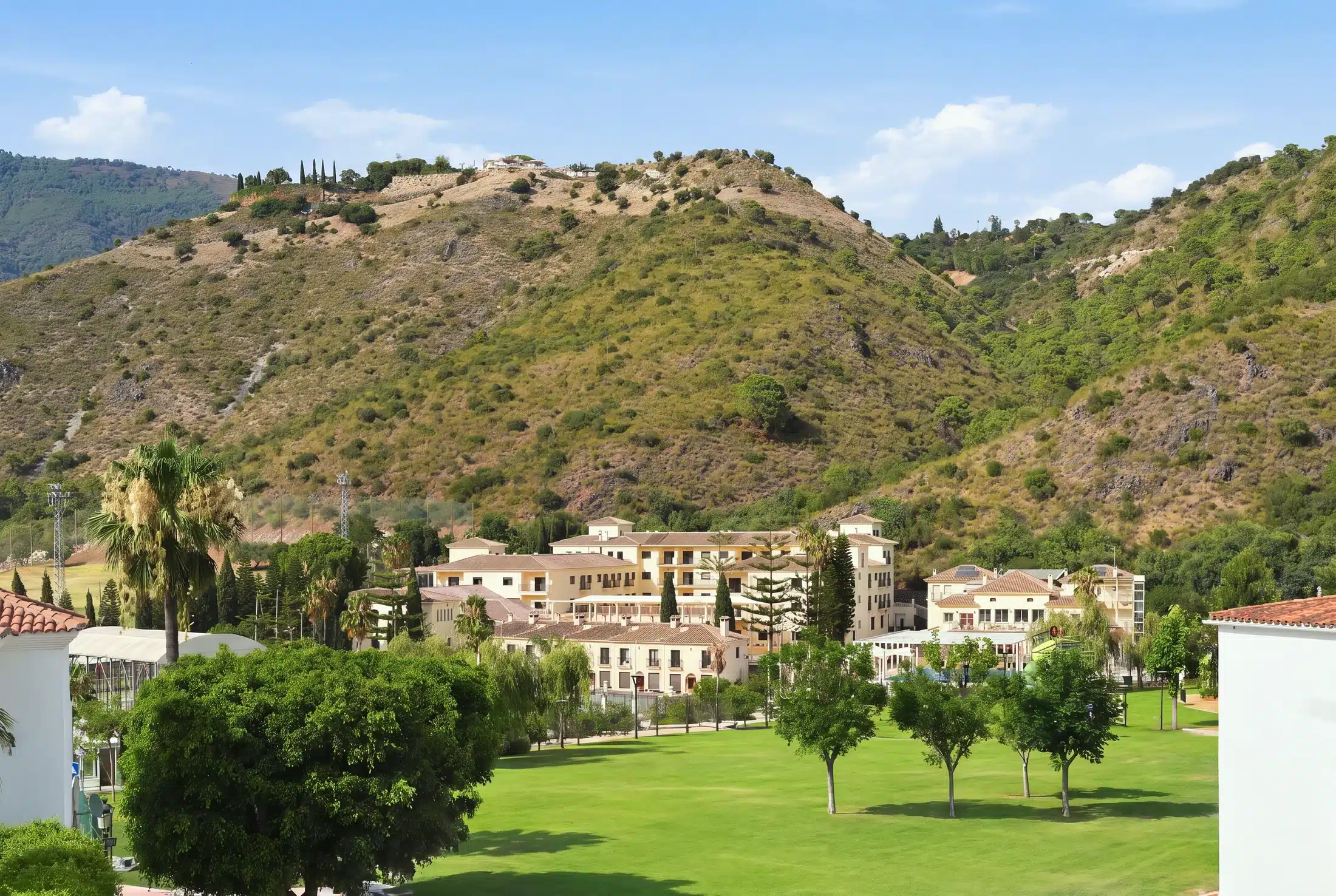 The Creators International School campus seen across the lawn, with the hills of Benahavís behind